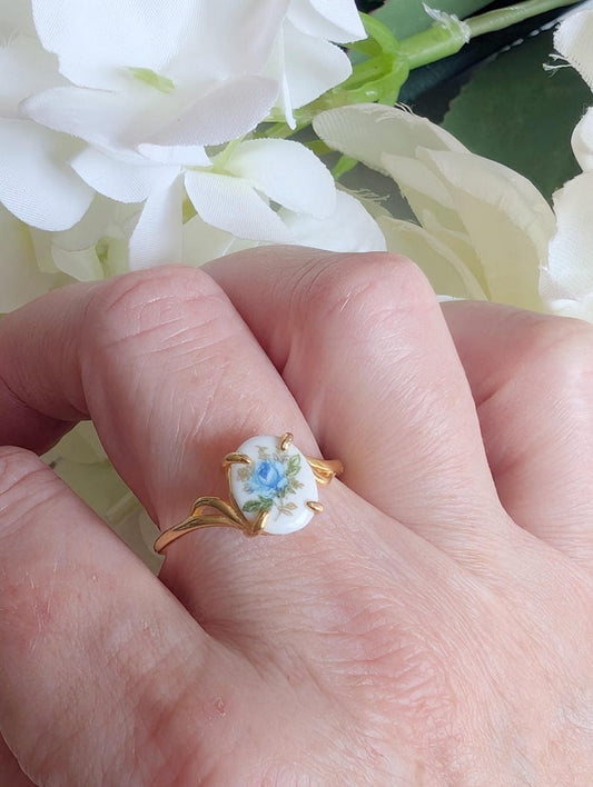 Hand wearing a Gold Vermeil Blue Rose Ring - 925 Sterling Silver - Victorian Floral Jewelry against a white flower background