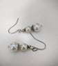 Pearl earrings with silver hooks on a light gray background