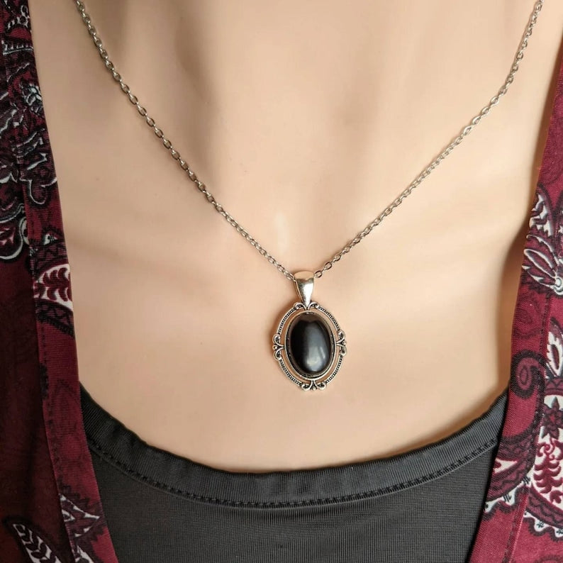 Black Obsidian Crystal Necklace - Silver Flourish Pendant Setting on a mannequin wearing a patterned garment.