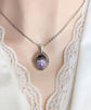 Purple Amethyst Crystal Necklace - Silver Flourish Pendant Setting on a mannequin wearing a lace top.