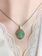 Green Aventurine Crystal Necklace - Silver Flourish Pendant Setting on a mannequin wearing a lace garment