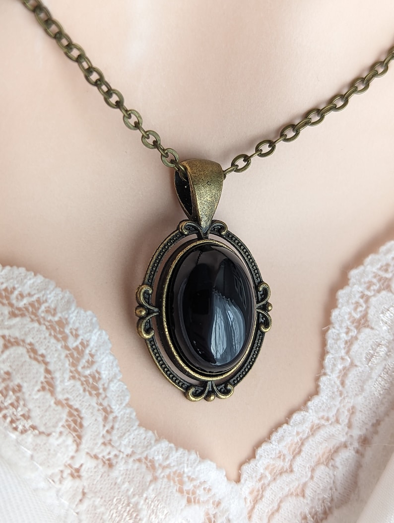 Black Obsidian Crystal Necklace - Bronze Flourish Pendant Setting on a mannequin bust wearing lace