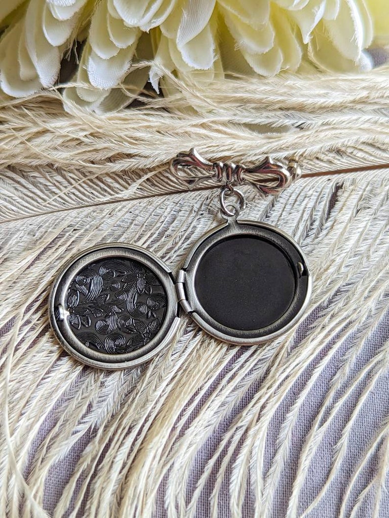 Open view of silver round floral etched locket brooch pin by Papillion Era