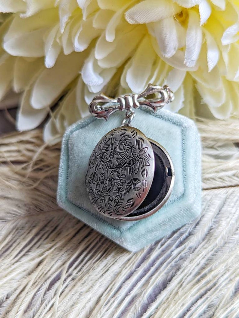 Silver round floral etched locket brooch pin partly open, by Papillion Era