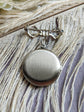 Back view of silver round floral etched locket brooch pin by Papillion Era