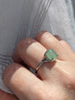 Natural Green Aventurine Solitaire Ring - Sterling Silver - Handmade Gemstone Jewelry - Made in Toronto against a light fabric background
