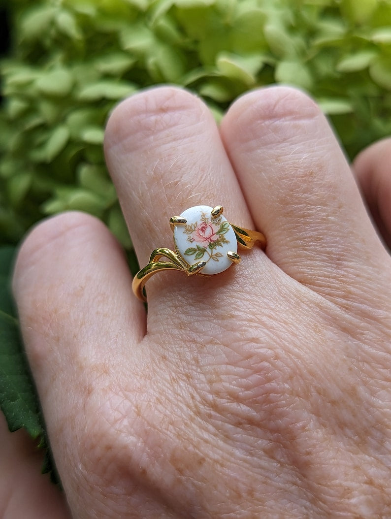 Pink Rose Cameo Ring - Gold Vermeil Sterling Silver Adjustable Band on a hand against a green leafy background