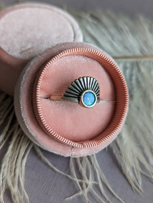 Art Deco Fan Ring with Iridescent Blue Opal - Silver Finish in a pink velvet ring box on a textured surface