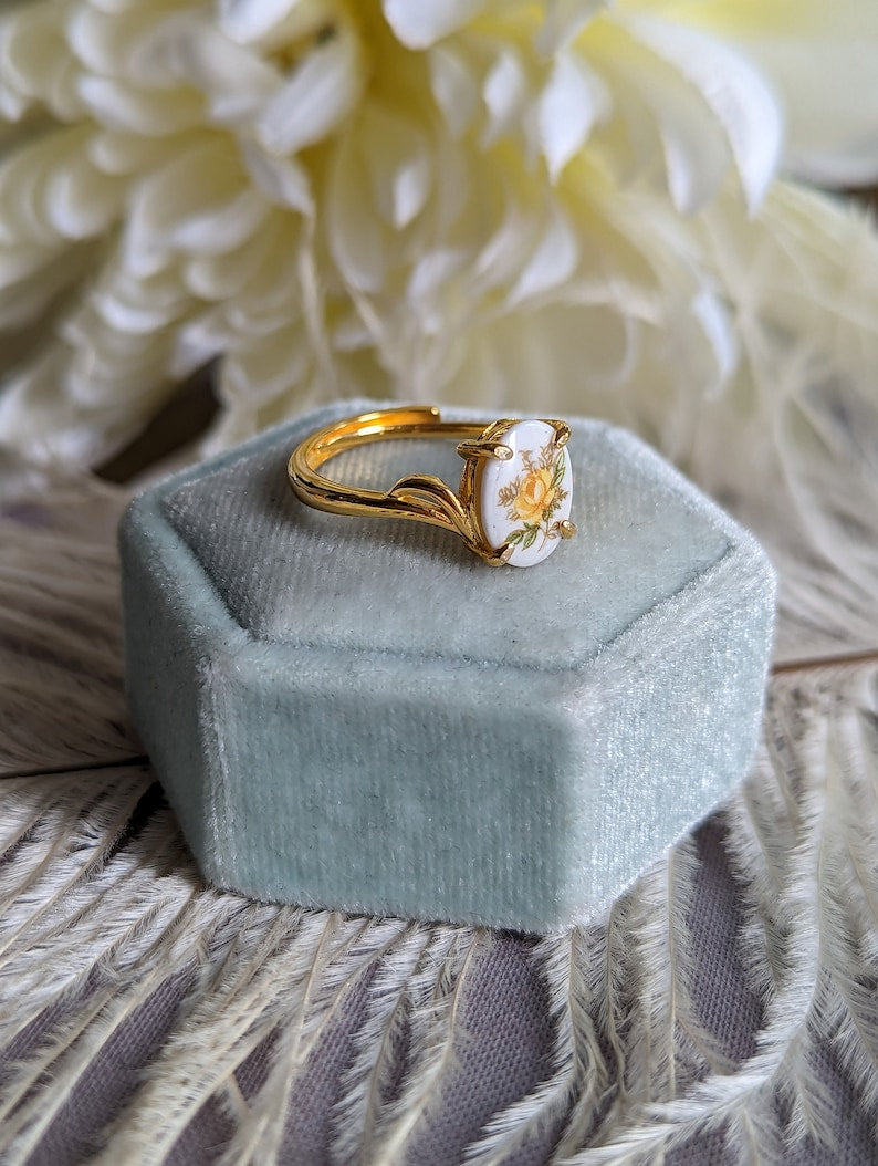 Gold Vermeil Blue Rose Ring - 925 Sterling Silver - Victorian Floral Jewelry in a light blue velvet box on a textured surface with flowers in the background