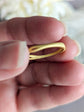 Gold ring held between fingers to show 925 silver stamp with a blurred background