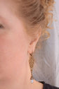 Close-up of a woman wearing a Long Victorian Pearl Drop Earrings- Bronze Filigree Bridal Dangle.