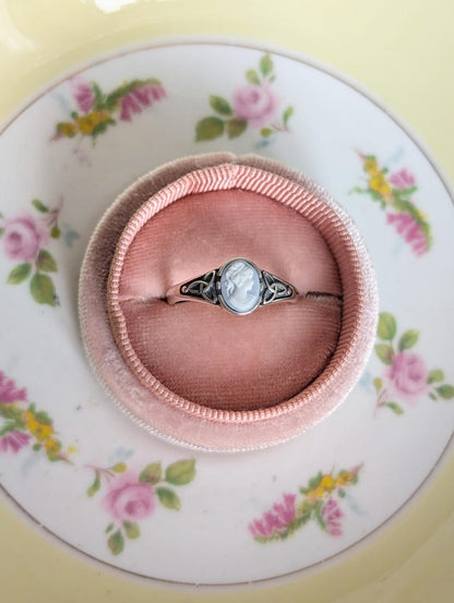 925 Sterling Silver Celtic Knot Cameo Ring - Heritage Style Jewelry with a white on blue cameo displayed on a jewelry box on a floral plate