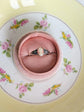 925 Sterling Silver Celtic Knot Cameo Ring - Heritage Style Jewelry with an ivory on carnelian cameo in a pink cushion on a floral teacup