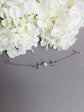 Silver Swallow Bracelet: Glass Pearl Bird Jewelry with Toggle Clasp on a gray surface with white flowers.