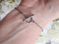 Close up of toggle clasp on a wrist with a floral background