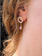 Close-up of an ear wearing a gold and Handmade Pearl and Fire Opal earrings