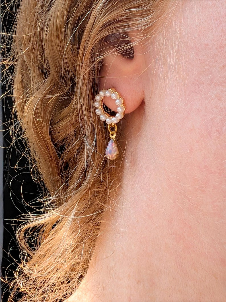 Close-up of an ear wearing a gold and Handmade Pearl and Fire Opal earrings