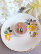 Handmade ivory on black cameo earrings with gold Fleur de Lis connectors and cognac Austrian crystals on a floral teacup.