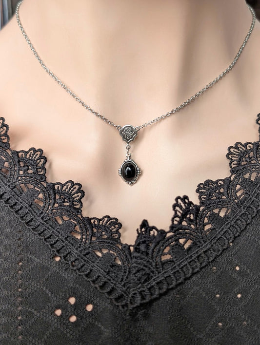 Necklace with a black onyx pendant on a mannequin wearing a black lace top.