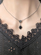 Necklace with a black onyx pendant on a mannequin wearing a black lace top.