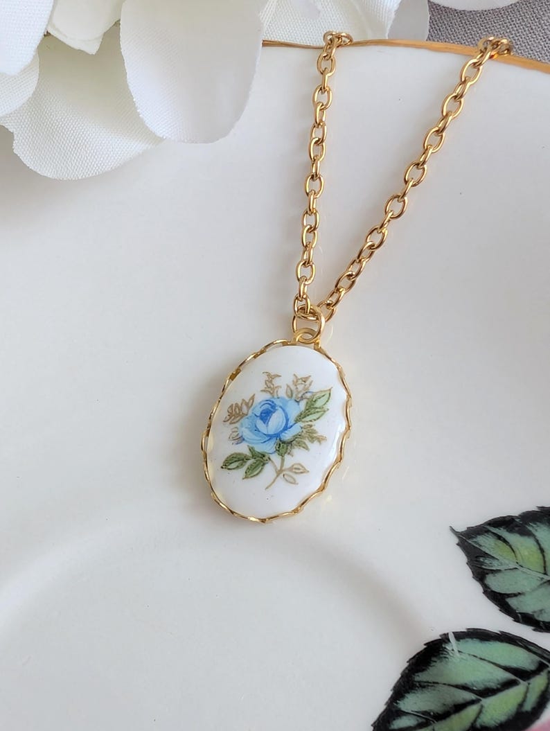Blue Rose Vintage Porcelain Necklace - 1980s Limoges Style - Brass Setting on a white background