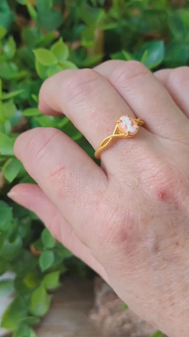 Matte gold cameo ring with single loop shoulder detail on model finger.