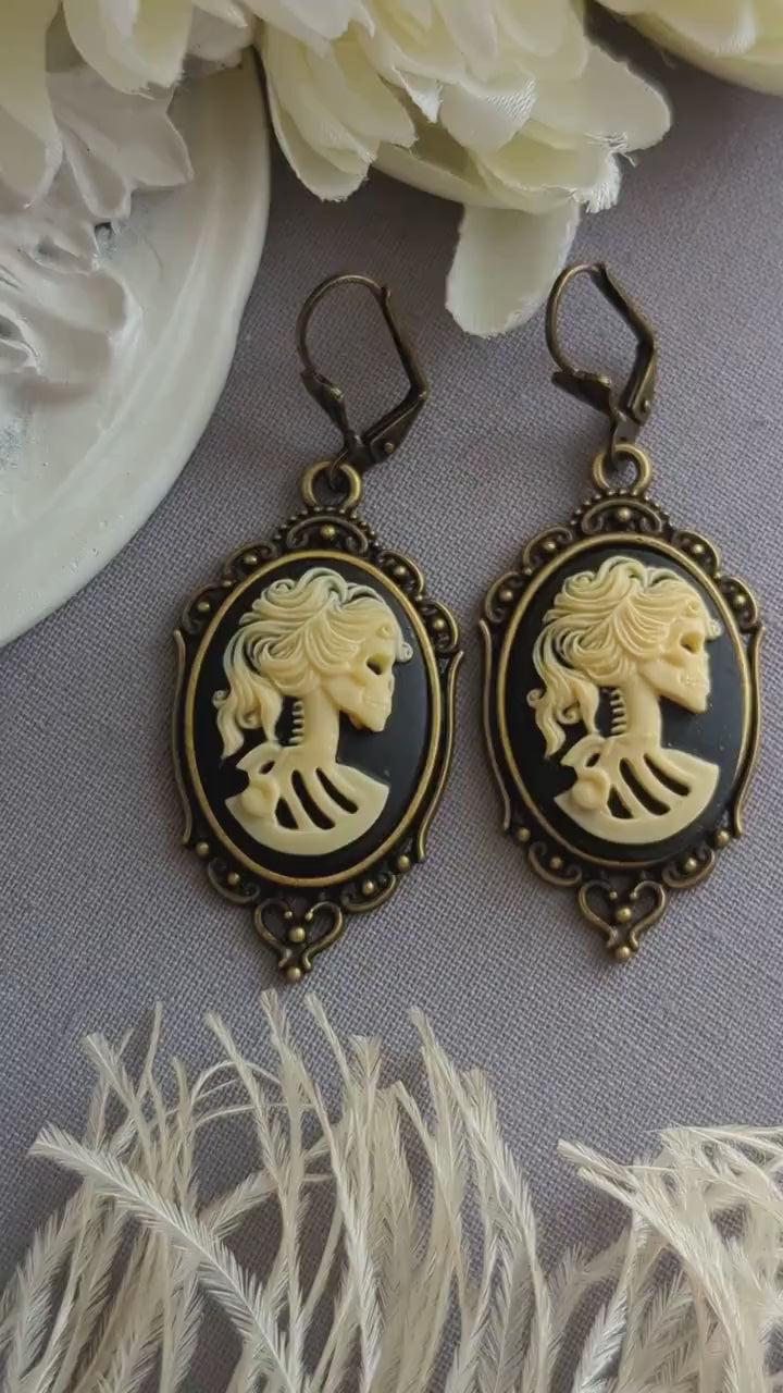 Pair of gothic black skull cameo drop earrings with detailed ivory lolita skull reliefs.
